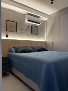 尤西德福拉hihome - Independência 915的一间卧室配有一张带蓝色毯子的床