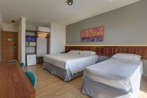 弗洛里亚诺波利斯波尔图索尔海滩酒店的酒店客房设有两张床和一张桌子。