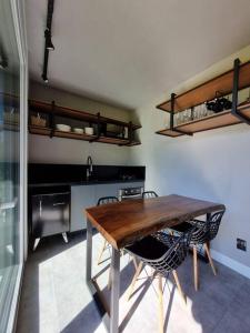 加里波第TinyWine House Vale dos Vinhedos的厨房配有木桌和两把椅子