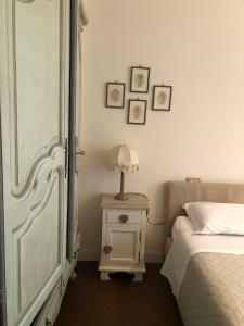 利维松多里Colle House的一间卧室配有一张床和一张带台灯的桌子