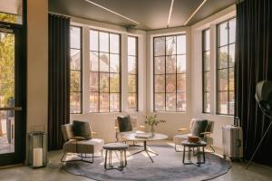 剑桥Sonder 907 Main的客厅配有椅子和桌子,设有窗户