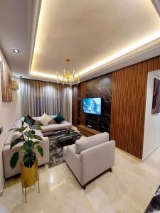 卡萨布兰卡modern apartment opposite the Hassan2 mosque, very well equipped and stylish, 85 m² with gym and direct sea view with underground garage. (couple of Arab origin without marriage certificate will be refused)的带沙发和电视的客厅