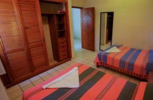 埃斯孔迪多港Bungalows Oasis的一间卧室配有两张床和镜子