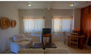 埃斯孔迪多港Bungalows Oasis的客厅配有沙发、椅子和桌子