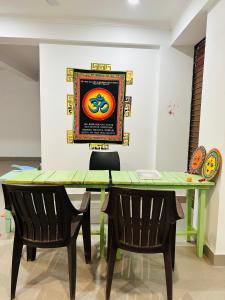 德拉敦wuiD stayin wakeupinDoon的餐桌、两把椅子和墙上的绘画