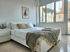 贝鲁特Sunny Eclectic 3BR house in Gemmayze的卧室配有一张白色的床,床上有毯子