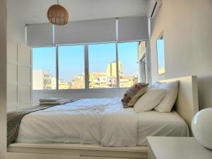 贝鲁特Sunny Eclectic 3BR house in Gemmayze的一间卧室设有一张大床和大窗户
