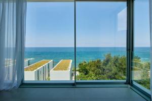 朱拜勒Amchit Bay Beach Residences 3BR Rooftop w Jacuzzi的客房设有大窗户,享有大海美景。