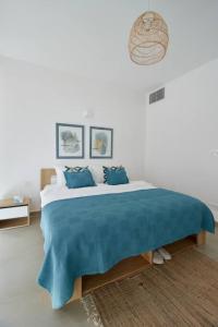 朱拜勒Amchit Bay Beach Residences 3BR Rooftop w Jacuzzi的一间卧室配有一张带蓝色毯子的大床