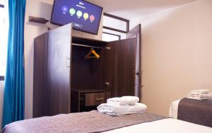 阿雷基帕Hotel La Casa de Irma的一间设有床铺和镜子上方电视的房间