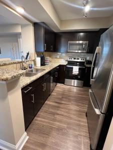 夏洛特Camden Grandview! Spacious 2 Bed, 2 Bath Uptown Gem in the Heart of the City-Parking-Wi-Fi的厨房配有黑色橱柜和不锈钢冰箱