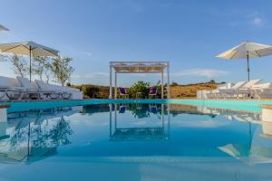 马林堡Monte Do Malhao - Art, Eco & Spa的一个带白色椅子和遮阳伞的游泳池