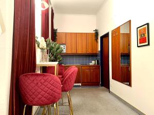 维也纳Central - 30 m² - Next to Augarten的厨房配有2把红色椅子和桌子