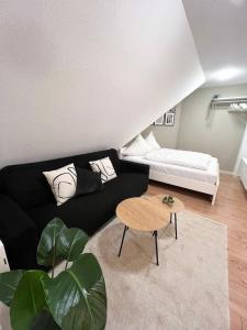 梅明根NAMI - ROBIN - Helle Apartments mitten in der Stadt的客厅配有黑色沙发和桌子