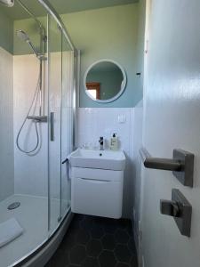 韦斯特兰Captain's Lounge - Bungalow XL的带淋浴和盥洗盆的白色浴室