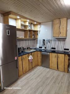 亚布卢尼齐亚Котеджі Цімбори的厨房配有不锈钢冰箱和木制橱柜