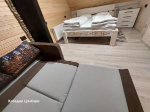 亚布卢尼齐亚Котеджі Цімбори的带沙发和毛巾桌的客房