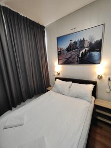乌得勒支荷兰旅舍酒店的卧室在窗户前配有一张白色大床