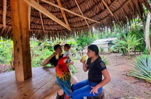 MazánARAPARI AMAZON LODGE的坐在女人旁边,有鹦鹉的女人