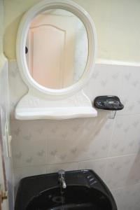 科帕卡巴纳Ima Sumaj Hostel的浴室设有黑色厕所上方的镜子