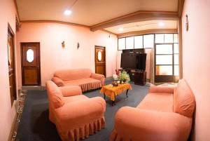 科帕卡巴纳Ima Sumaj Hostel的客厅配有橙色家具和电视