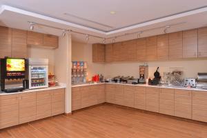 吉列TownePlace Suites by Marriott Gillette的一个带木制橱柜和电视的大厨房