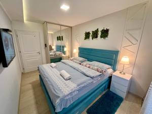 兹拉蒂博尔Apartmani SLEEP&JOY的一间卧室配有蓝色的床和镜子