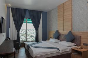 埃尔比勒埃森纳帕酒店的一间卧室设有一张床和一个大窗户