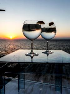 切法卢Casa Vela的两杯酒杯坐在海洋前的桌子上