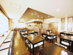 岛田岛田吉田国际鲁特因酒店的一间空餐厅,配有木桌和椅子