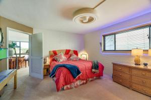 科洛阿Colorful Poipu Condo with Expansive Ocean Views!的一间卧室设有红色的床和窗户。