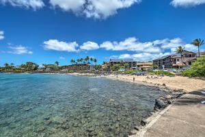 科洛阿Colorful Poipu Condo with Expansive Ocean Views!的棕榈树度假村前的海滩