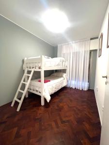 门多萨Hermoso, amplio y nuevo departamento, en la mejor ubicacion de la ciudad de Mendoza的一间卧室设有两张双层床和梯子