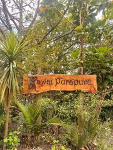 奥克兰卡怀伊普拉普拉瑜伽中心度假酒店的树木花园中间的一个标志