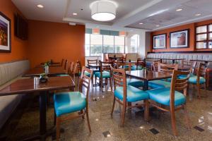 哥伦比亚Drury Inn & Suites Columbia Stadium Boulevard的餐厅设有木桌和蓝色椅子