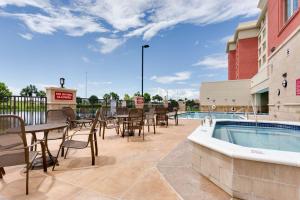 迈尔斯堡Drury Inn & Suites Fort Myers Airport FGCU的一个带桌椅的庭院和一个游泳池