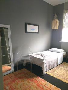 萨尔瓦多Erva Cidreira Hostel的一间卧室配有一张床、镜子和椅子