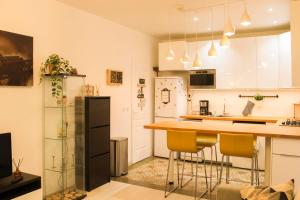 巴黎Cosy 38 m love nest near Centquatre-Paris的厨房配有白色橱柜和带黄色椅子的台面