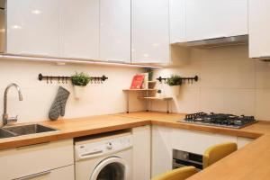 巴黎Cosy 38 m love nest near Centquatre-Paris的厨房配有白色橱柜和洗碗机。