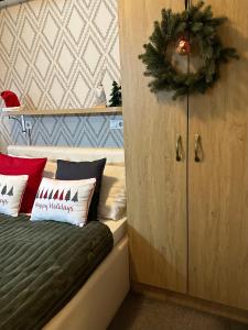 巴尼亚卢卡Hotel Banja Luka的卧室配有带圣诞花圈的床