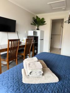 Port Vincent文森特港汽车旅馆及公寓的一间卧室配有蓝色的床和桌椅