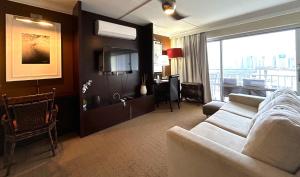 檀香山Ilikai Apt 2127 - Spacious Studio with Spectacular Ocean & Harbor Views的带沙发和大窗户的客厅