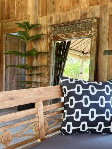 BalianDesa Cabins的一张带枕头的长凳旁的镜子