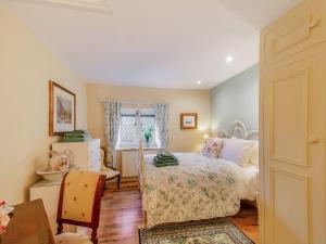 Riverside Cottage的一间卧室配有一张床、一张桌子和一个窗户。