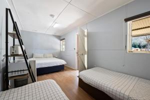 布赖特明亮小屋公园酒店的一间卧室设有两张床和梯子