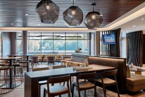 罗阿诺SpringHill Suites by Marriott Roanoke North的一间带桌椅的餐厅和一间酒吧