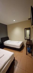 甘榜巴鲁泰斯樱花经济型酒店 的一间卧室配有两张床、一张桌子和一面镜子
