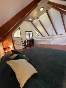 帕皮提Fare APE BUNGALOW F3 Atypical local style的阁楼卧室配有一张带枕头的大床