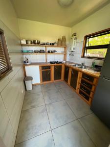 帕皮提Fare APE BUNGALOW F3 Atypical local style的一个带木制橱柜和窗户的小厨房