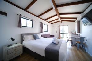 卧龙岗Lakeside Inn Wollongong的卧室配有一张白色大床和一张书桌
